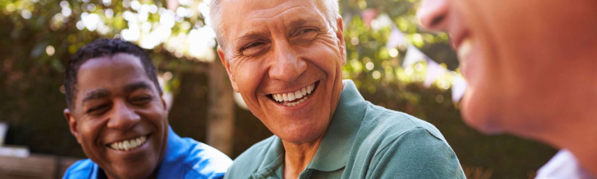 Mature Male Friends Socializing In Backyard Together