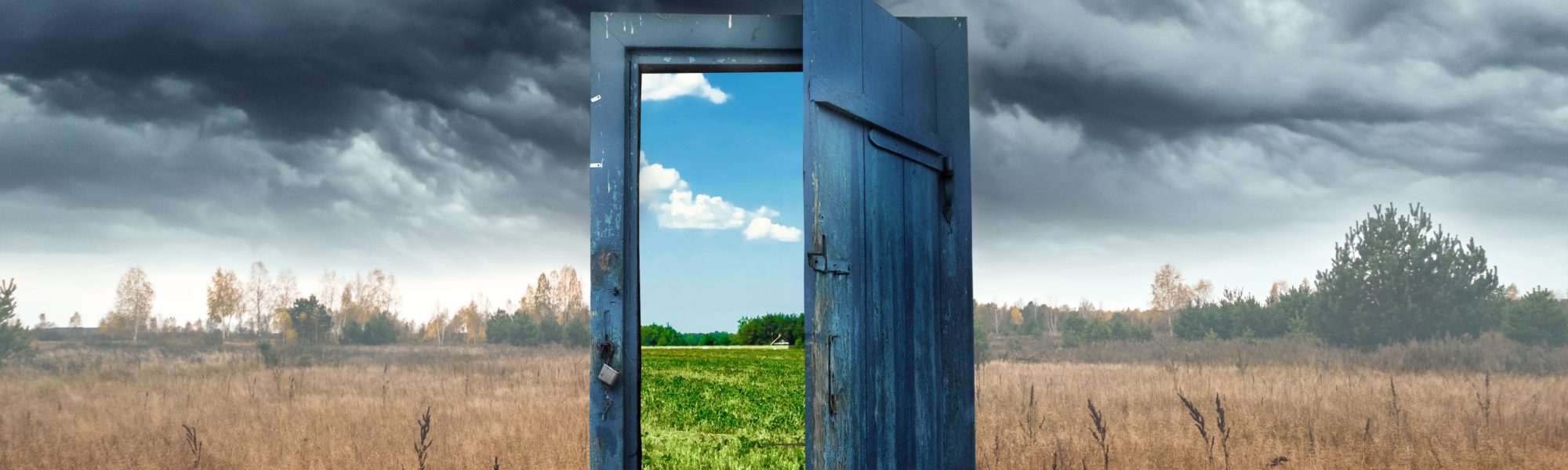 Creative background. Old wooden door, blue color, in the box. Transition to a different climate. The concept of climate change, portal, magic. Copy space.